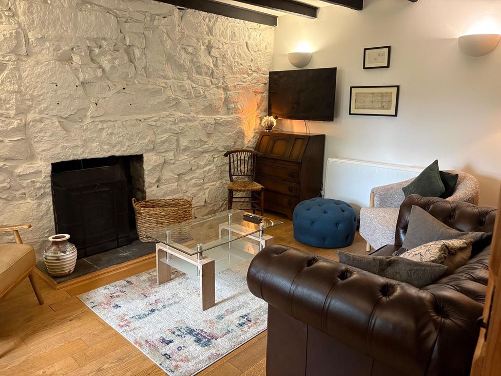 A living room with a coffee table and television at Cosy Cottage Retreat in Edinbane
