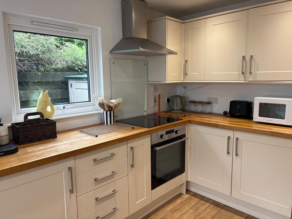 A kitchen with appliances and utensils at Cosy Cottage Retreat in Edinbane near Portree