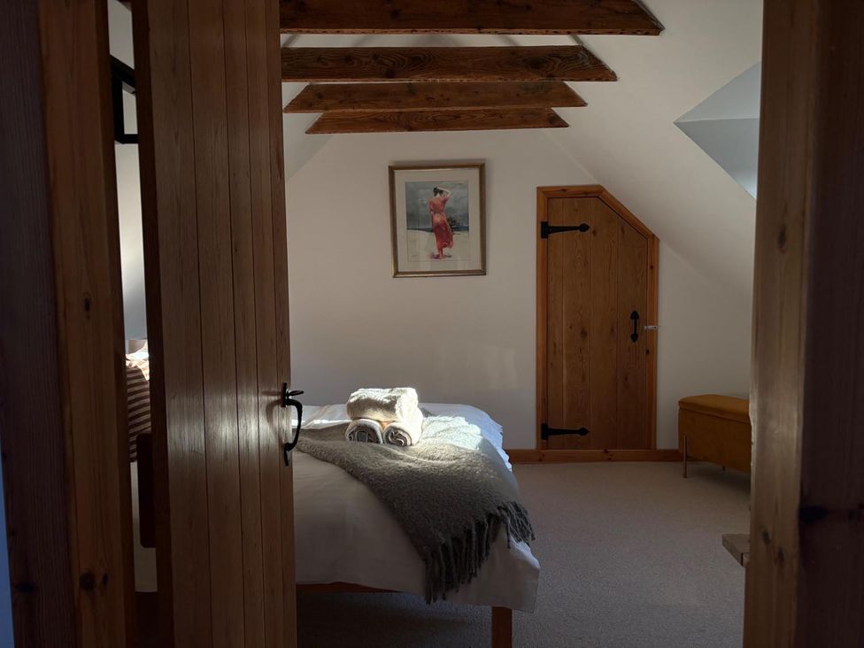 A bedroom with a bed and wooden features at Cosy Cottage Retreat in Edinbane