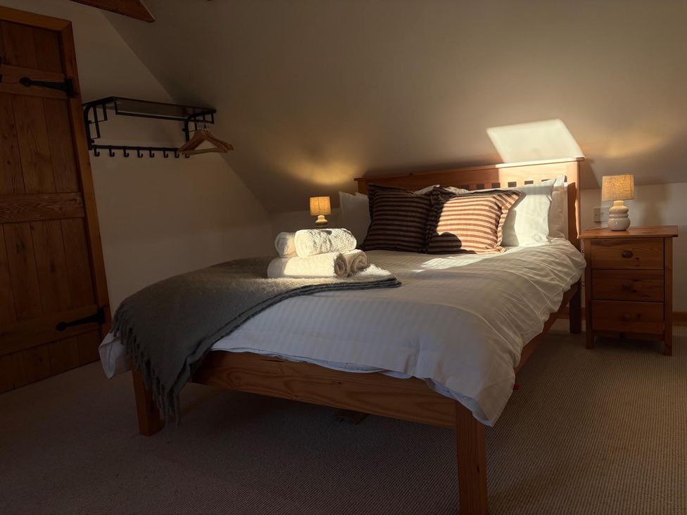A bedroom with a bed and nightstand at Cosy Cottage Retreat in Edinbane