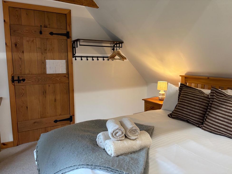 A bedroom with a bed and bedside table at Cosy Cottage Retreat in Edinbane near Portree