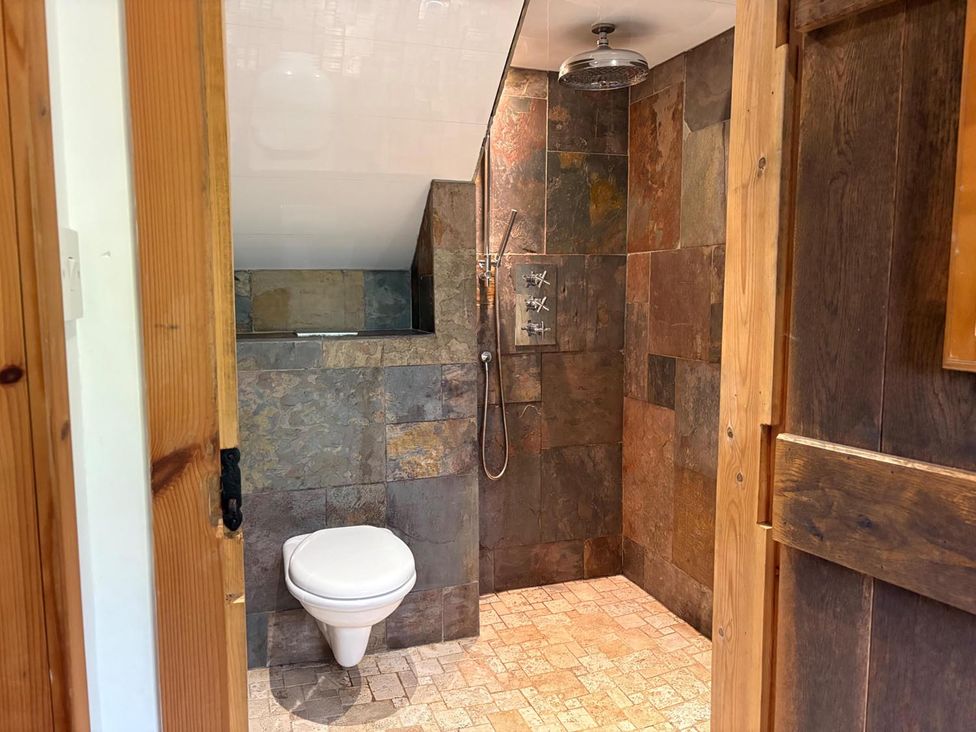 A bathroom with a toilet and shower area at Cosy Cottage Retreat in Edinbane
