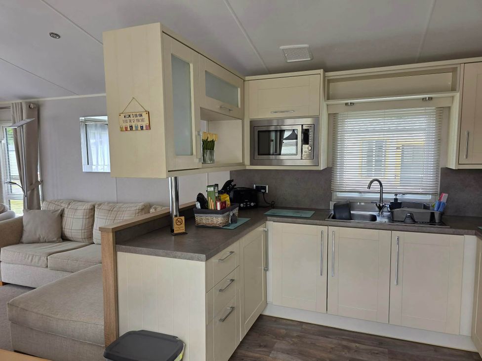 A kitchen with a microwave and sink at 3 Bed Lodge Sleeps 6 Decking Parking WiFi in Dunbar