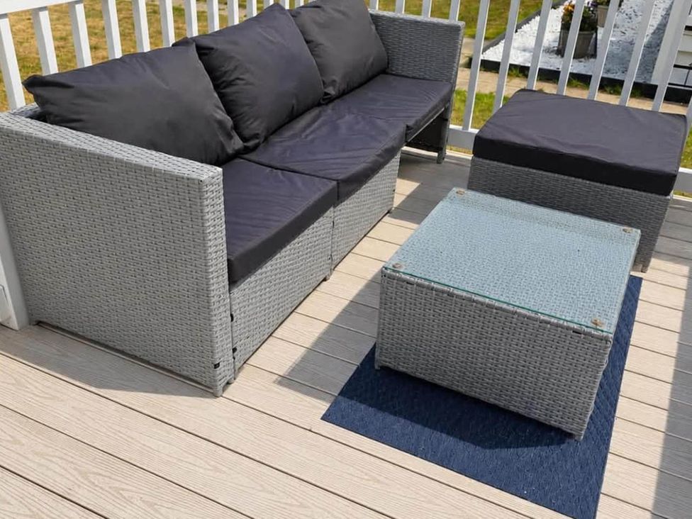 An outdoor seating area with a sofa and coffee table at 3 Bed Lodge Sleeps 6 Decking Parking WiFi, Dunbar