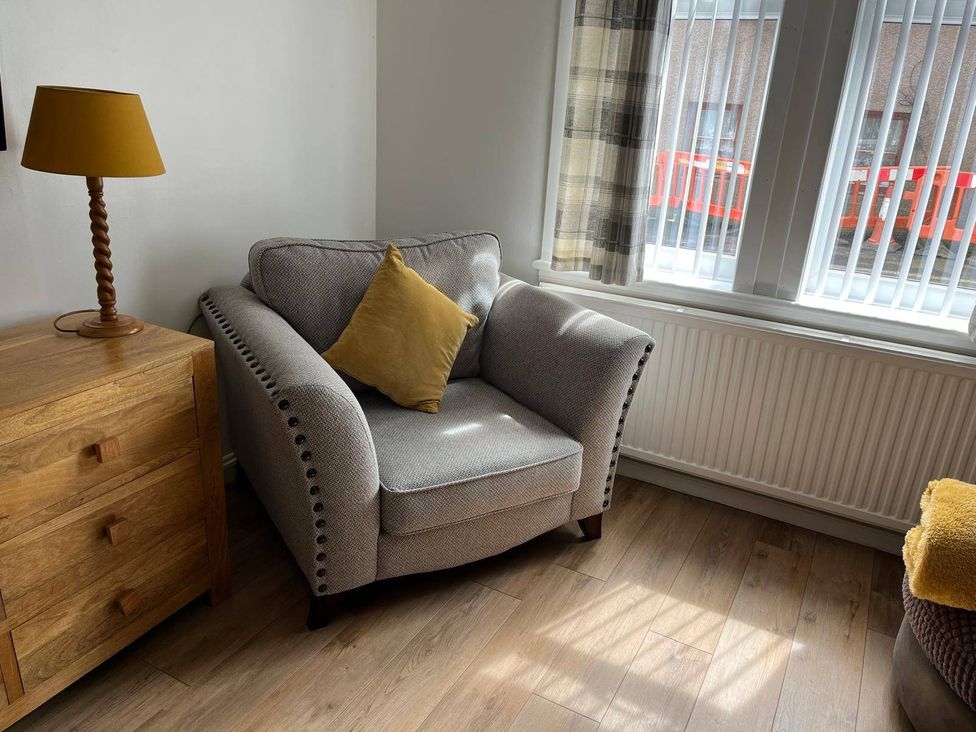 A chair with a cushion and a lamp next to a window at Costal Cottage Boddam Sleeps6 Pet Friendly Boddam