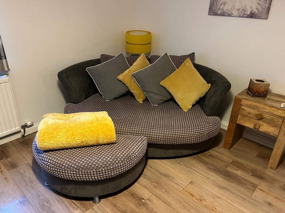 A sofa with cushions and a lamp at Costal Cottage Boddam Sleeps6 Pet Friendly Boddam