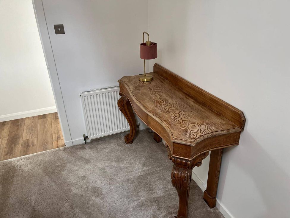 A console table with a lamp and radiator in the hallway at Costal Cottage Boddam Sleeps6 Pet Friendly Boddam