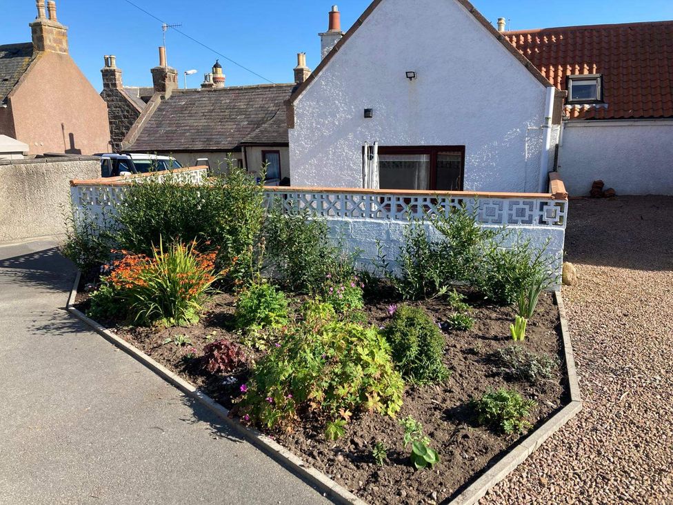 A garden bed with flowers and gravel at Costal Cottage Boddam Sleeps6 Pet Friendly Boddam