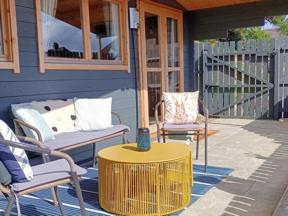 An outdoor seating area with chairs and a table at Fairvine Cabin Fort Augustus Mtn View Pet Friendly
