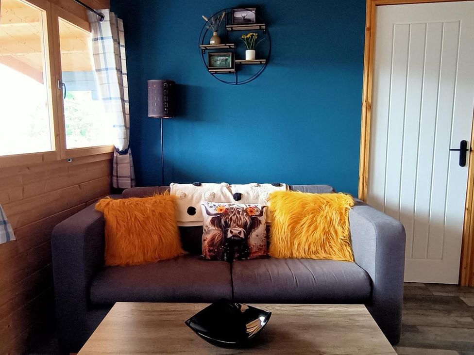 A living room with a sofa and pillows at Fairvine Cabin Fort Augustus Mtn View Pet Friendly in Fort Augustus