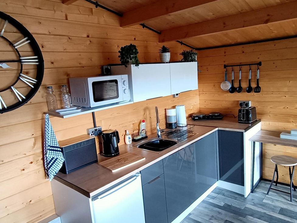 A kitchen with sink and microwave at Fairvine Cabin Fort Augustus Mtn View Pet Friendly