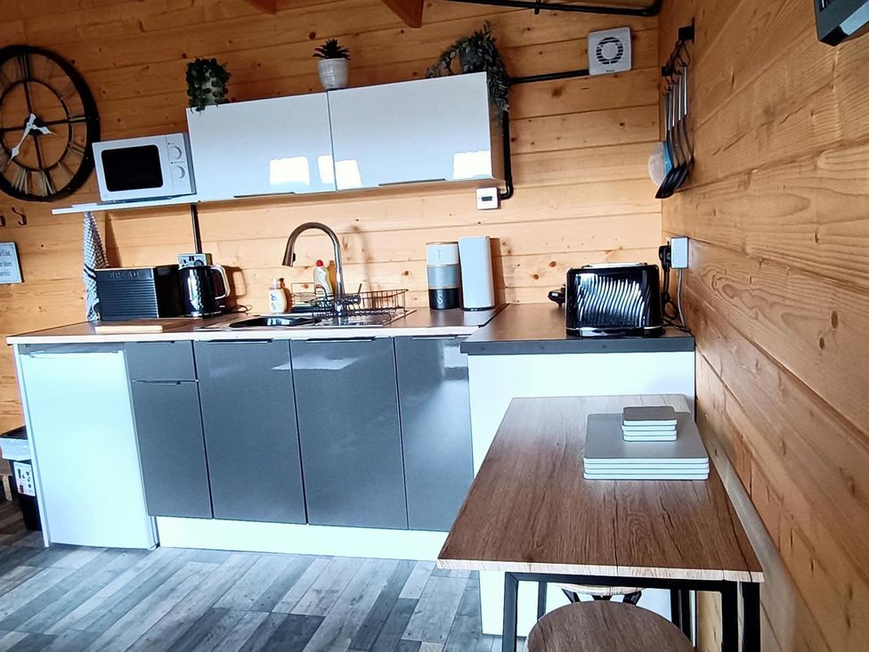 A kitchen with appliances and a table at Fairvine Cabin Fort Augustus Mtn View Pet Friendly, Fort Augustus