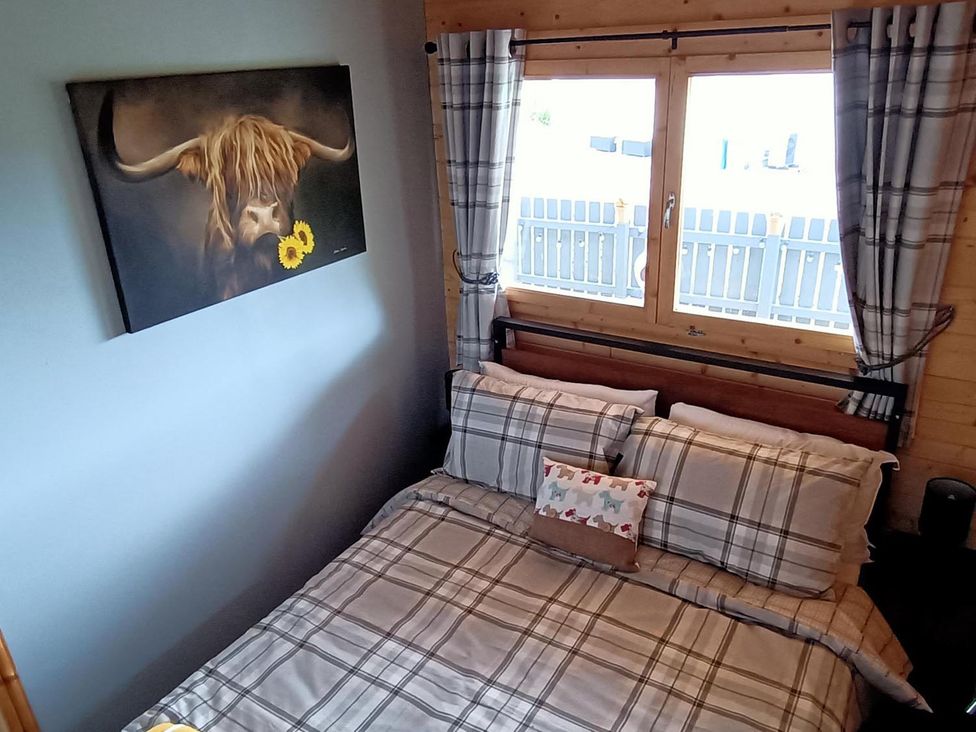 A bed with pillows and a painting in Fairvine Cabin Fort Augustus Mtn View Pet Friendly in Fort Augustus