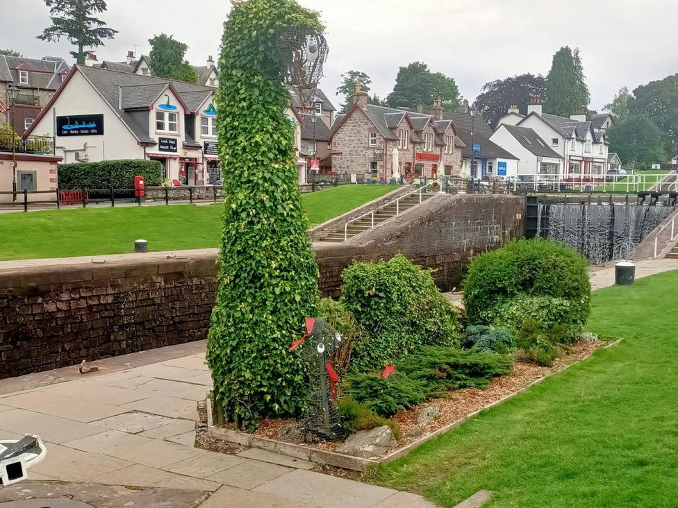 A garden with decorative plants in front of buildings at Fairvine Cabin Fort Augustus Mtn View Pet Friendly Fort Augustus