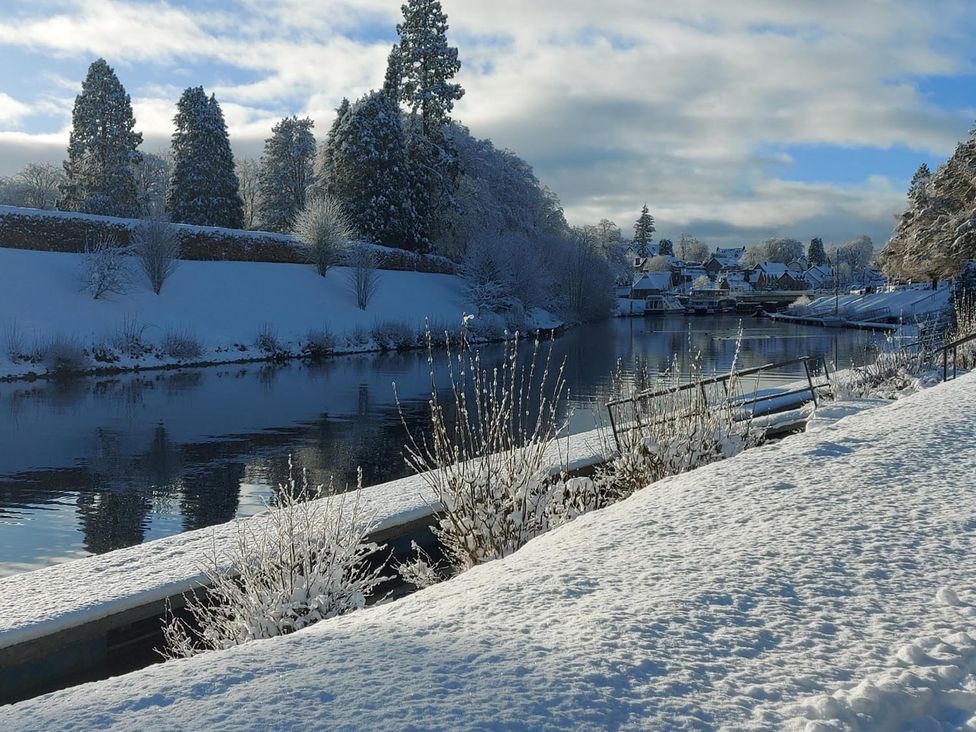 A river with snow-covered banks and trees at Fairvine Cabin Fort Augustus Mtn View Pet Friendly, Fort Augustus