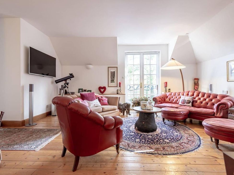 A living room with a sofa, television, and coffee table at Luxury Duplex Sleeps 2 Hot Tub Balcony Parking Duncrievie near Milnathort