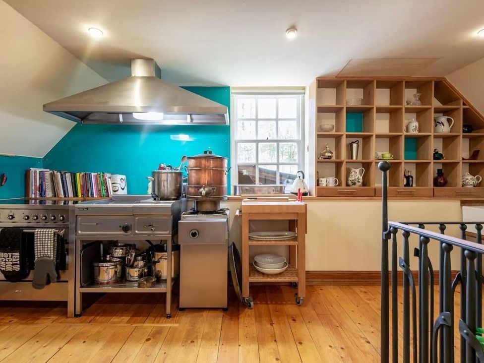 A kitchen with cooking equipment and open shelving at Luxury Duplex Sleeps 2 Hot Tub Balcony Parking in Duncrievie near Milnathort