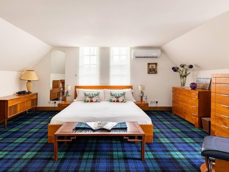 A bedroom with a bed and wooden furniture at Luxury Duplex Sleeps 2 Hot Tub Balcony Parking Duncrievie near Milnathort
