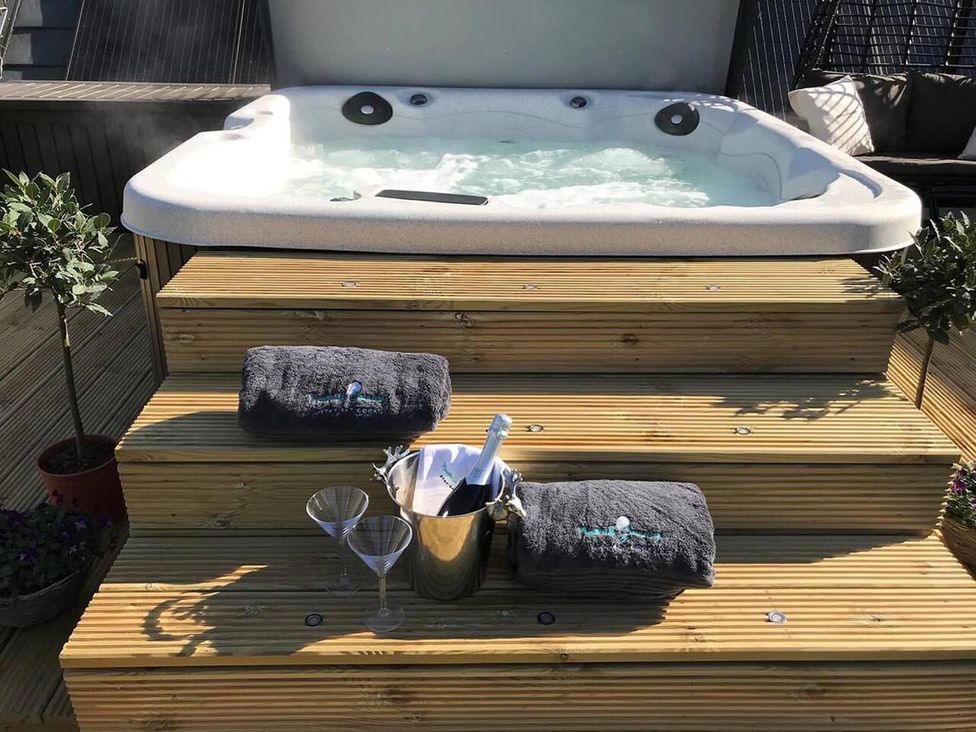 A hot tub with steps and towels at Luxury Duplex Sleeps 2 Hot Tub Balcony Parking Duncrievie near Milnathort