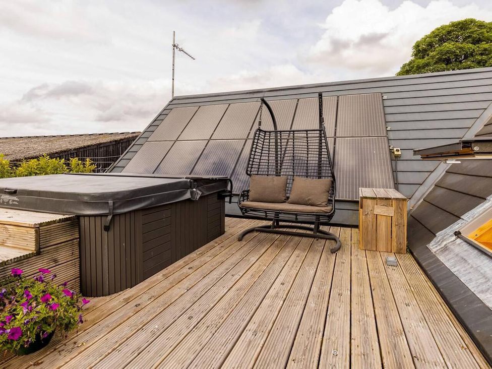 An outdoor space with a hot tub and hanging chair at Luxury Duplex Sleeps 2 Hot Tub Balcony Parking Duncrievie near Milnathort