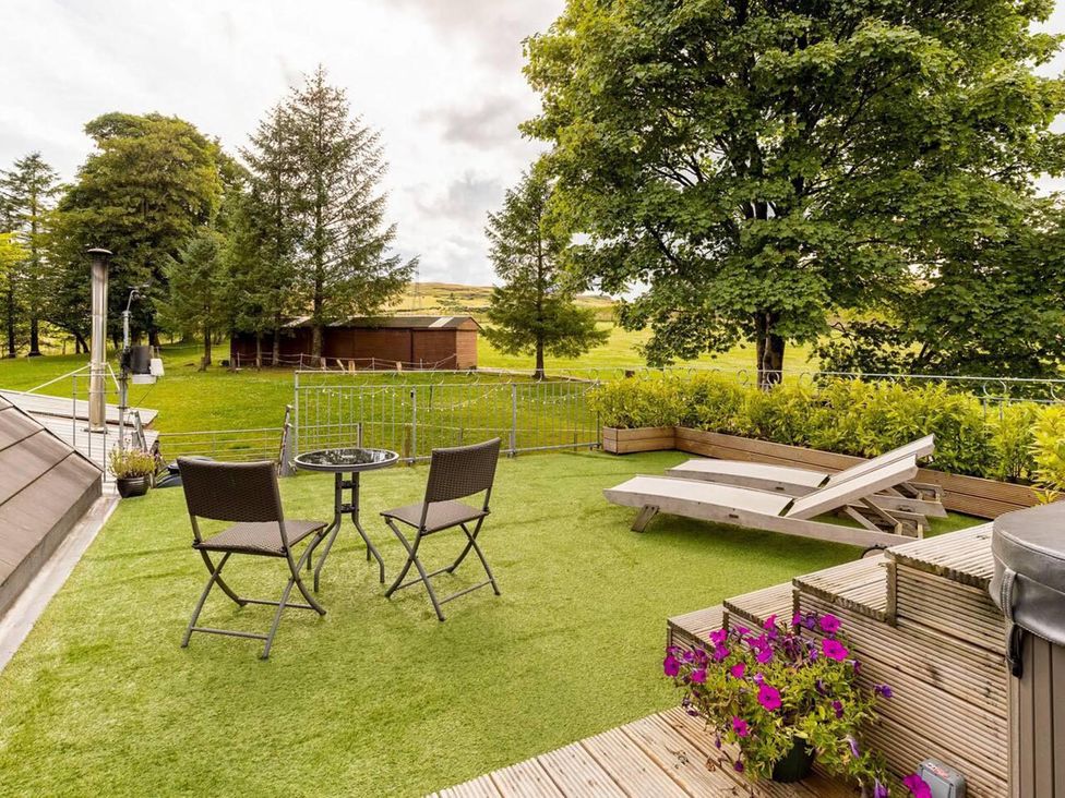 A garden with table and chairs and a sun lounger at Luxury Duplex Sleeps 2 Hot Tub Balcony Parking Duncrievie near Milnathort