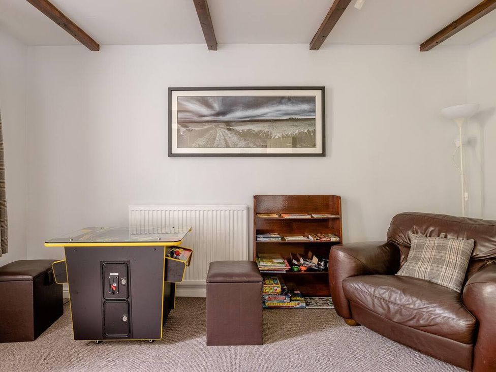 A snug with a sofa, shelf of books, games, and an artwork at OldMill 2Bed Sleeps6 PrivateGarden OptionalHotTub, Oakworth