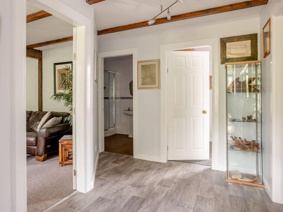 A hallway with a door and glass cabinet at OldMill 2Bed Sleeps6 PrivateGarden OptionalHotTub in Oakworth