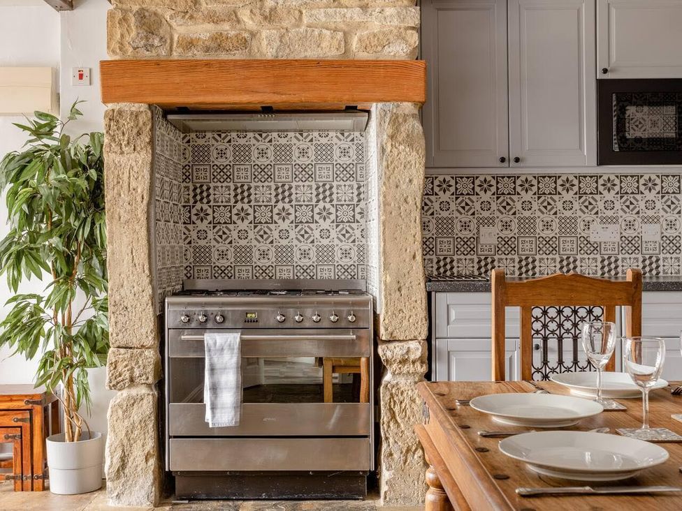A kitchen with an oven and dining table at OldMill 2Bed Sleeps6 PrivateGarden OptionalHotTub in Oakworth