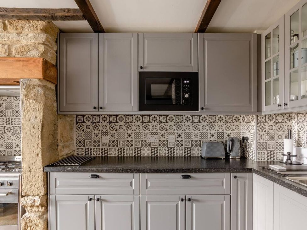 A kitchen with gray cabinets and a microwave at OldMill 2Bed Sleeps6 PrivateGarden OptionalHotTub in Oakworth