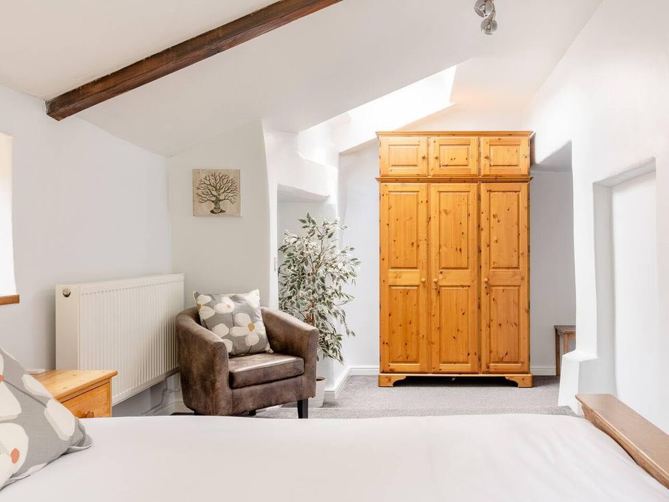 A bedroom with a wardrobe and armchair at OldMill 2Bed Sleeps6 PrivateGarden OptionalHotTub, Oakworth