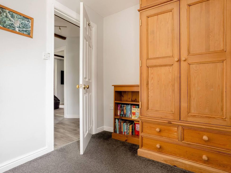 A bedroom with a wardrobe and bookshelf at OldMill 2Bed Sleeps6 PrivateGarden OptionalHotTub, Oakworth