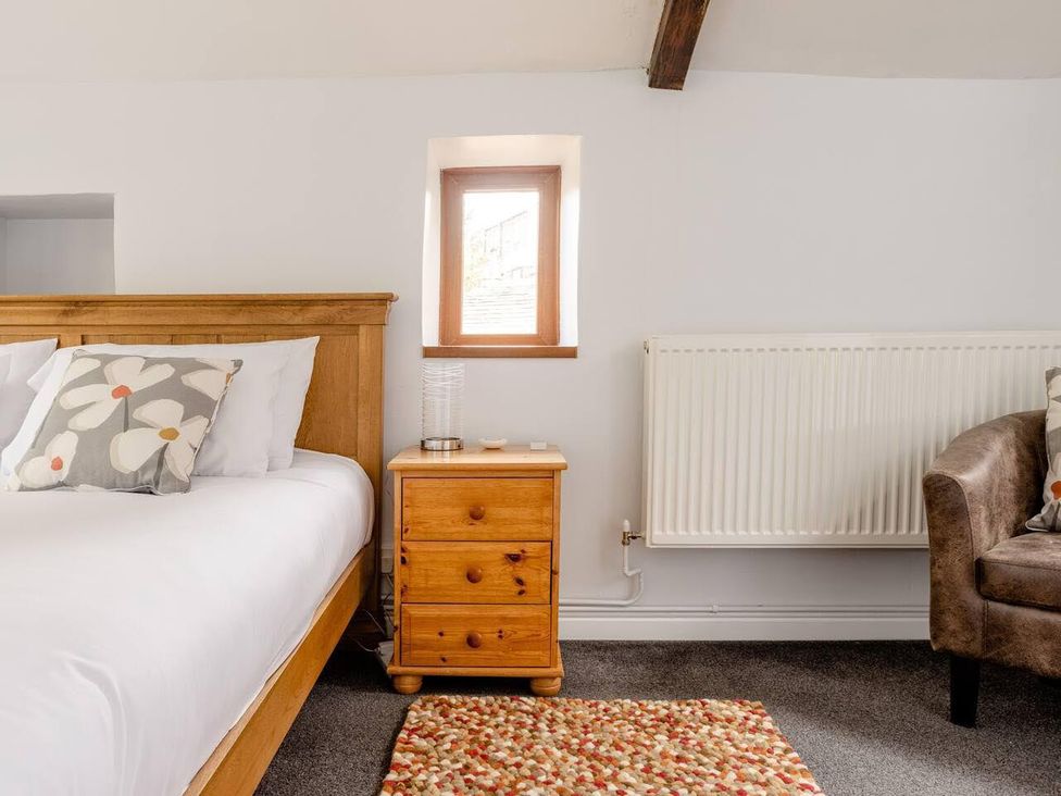 A bedroom with a bed and nightstand at OldMill 2Bed Sleeps6 PrivateGarden OptionalHotTub in Oakworth