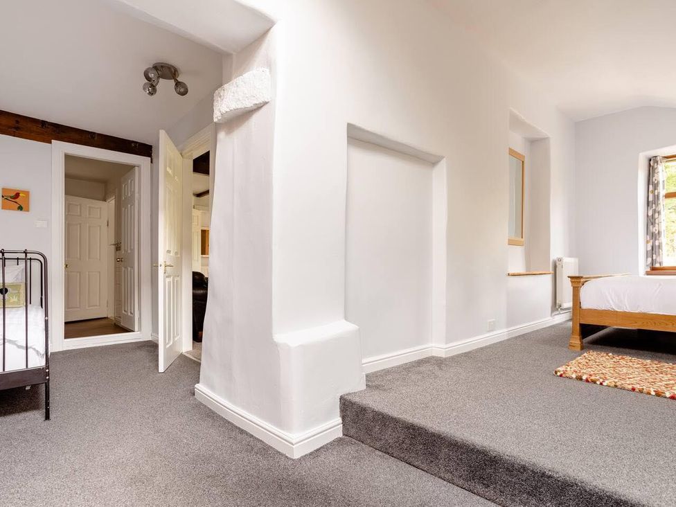 A bedroom with a bed and a door at OldMill 2Bed Sleeps6 PrivateGarden OptionalHotTub in Oakworth