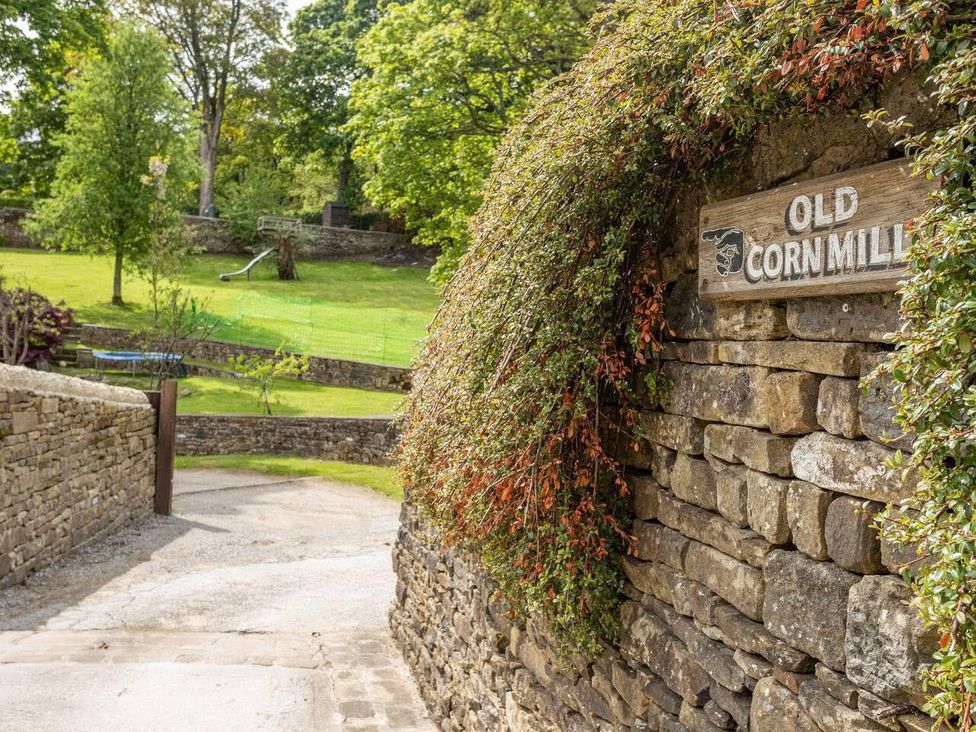A sign on a stone wall at Old Corn Mill in Oakworth