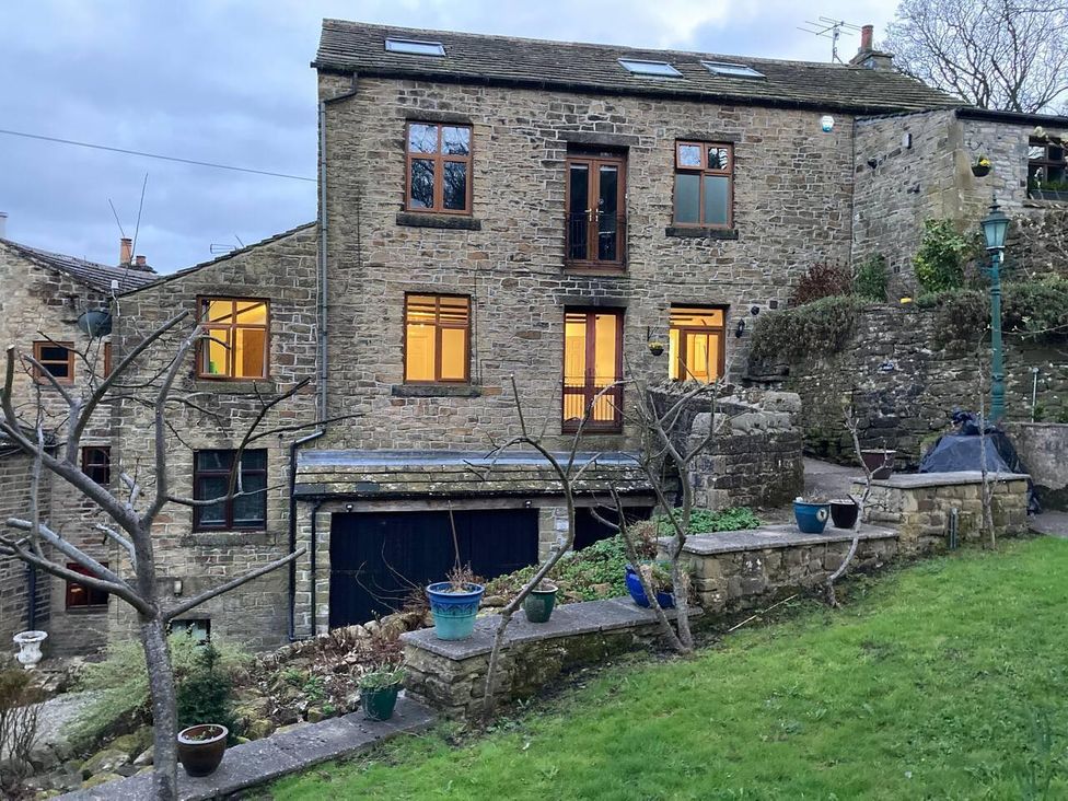 A stone building with windows and potted plants at OldMill 2Bed Sleeps6 PrivateGarden OptionalHotTub in Oakworth