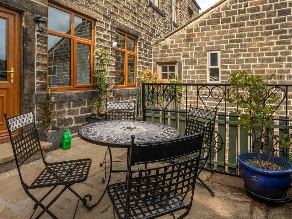 An outdoor patio with a table and chairs at OldMill 2Bed Sleeps6 PrivateGarden OptionalHotTub Oakworth