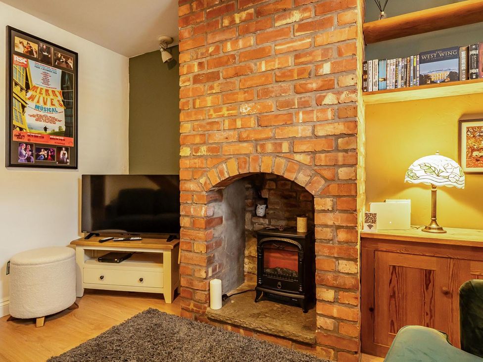 A living room with a television and fireplace at Quaint Cottage in Charming Evesham