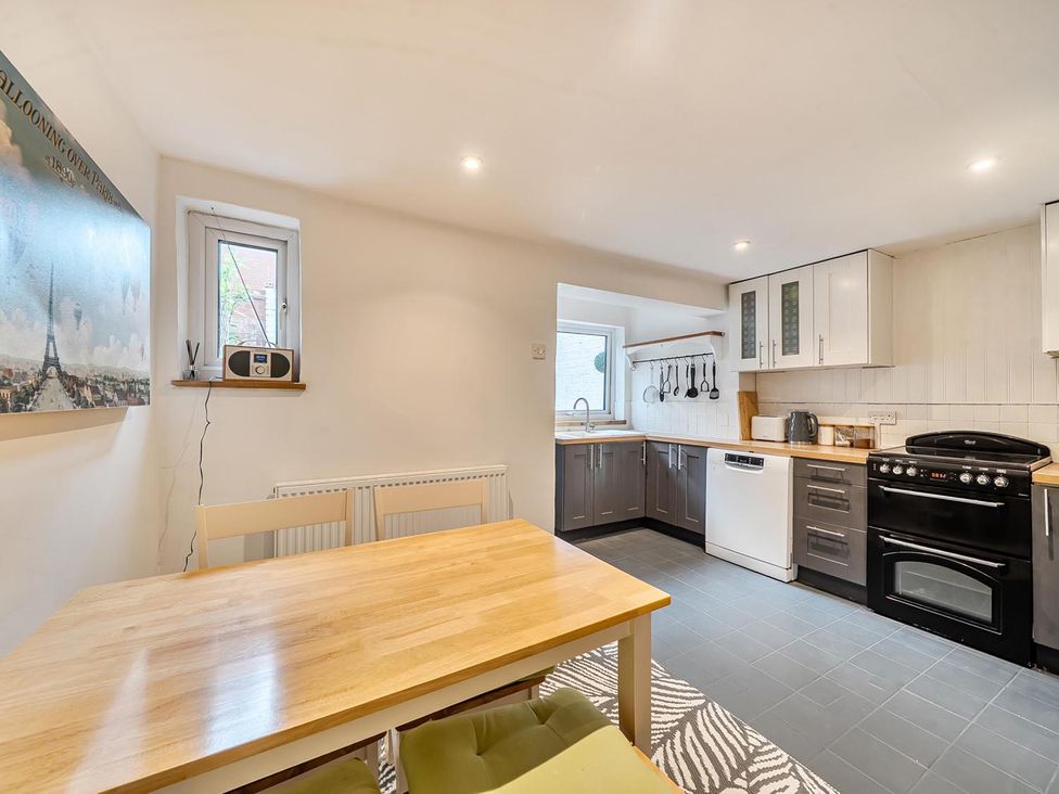 A kitchen with a table and chairs at Quaint Cottage in Charming Evesham