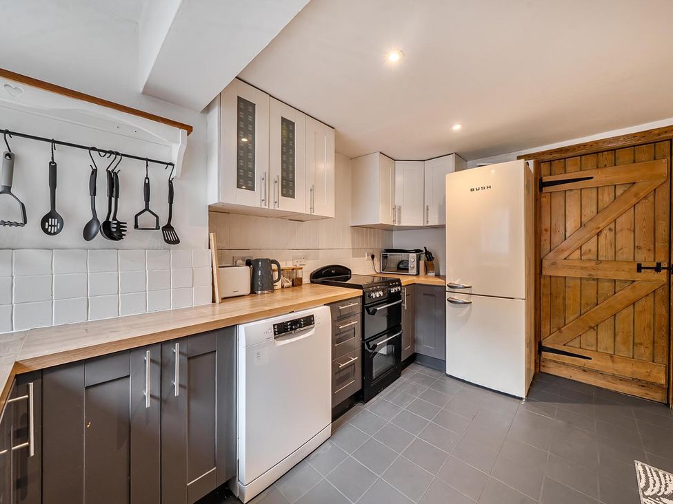 A kitchen with appliances and cabinets at Quaint Cottage in Charming Evesham