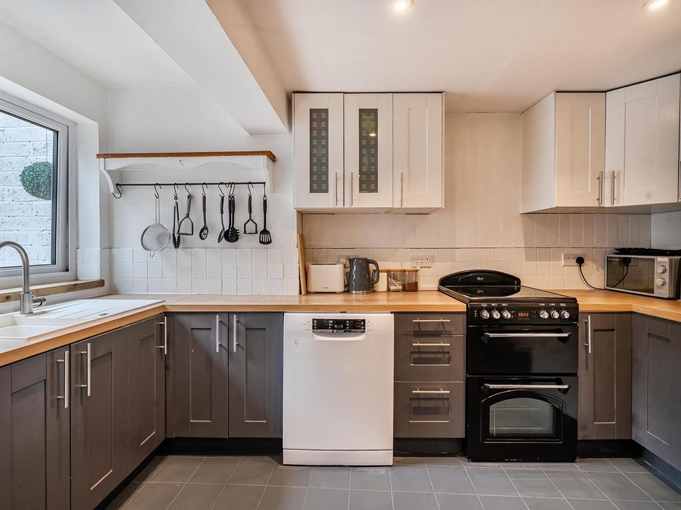 A kitchen with appliances and utensils at Quaint Cottage in Charming Evesham