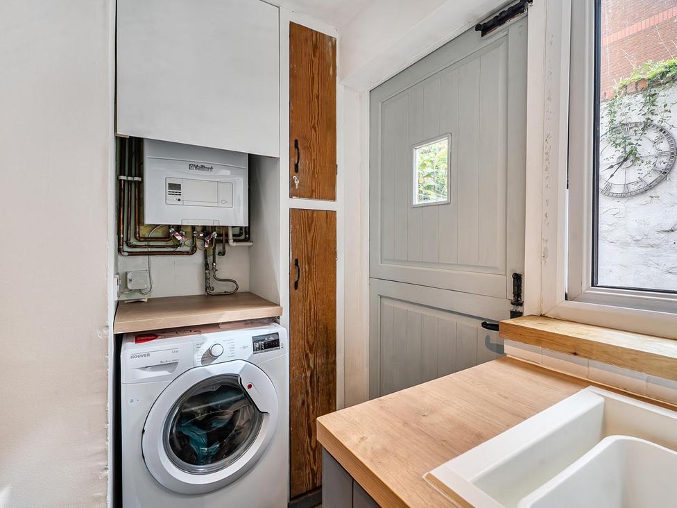 A laundry room with a washing machine and sink at Quaint Cottage in Charming Evesham