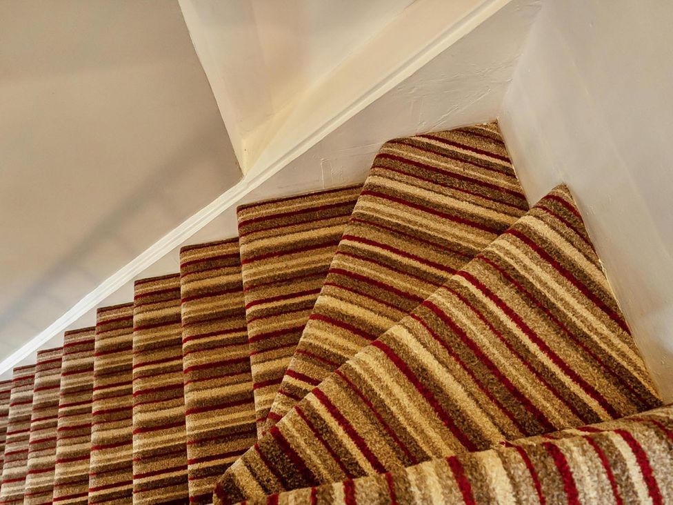 A staircase with patterned carpet at Quaint Cottage in Charming Evesham