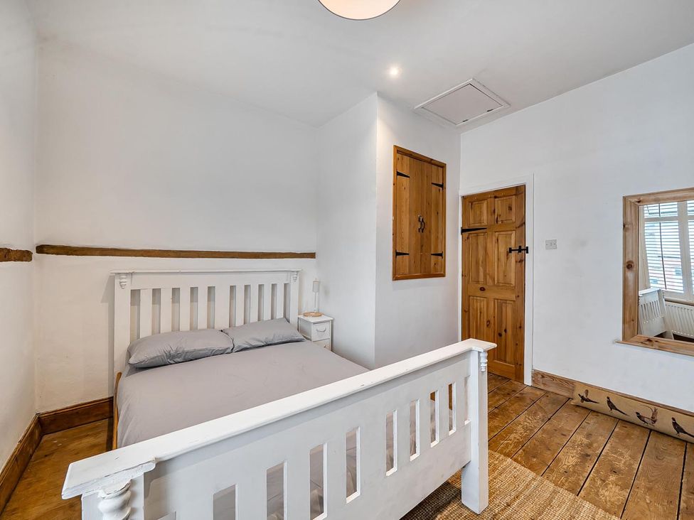 A bedroom with a bed and wooden features at Quaint Cottage in Charming Evesham