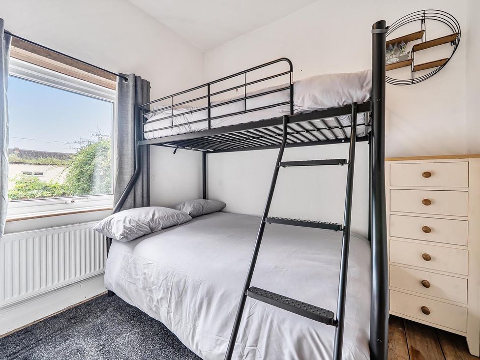 A bedroom with a bunk bed and a double bed at Quaint Cottage in Charming Evesham