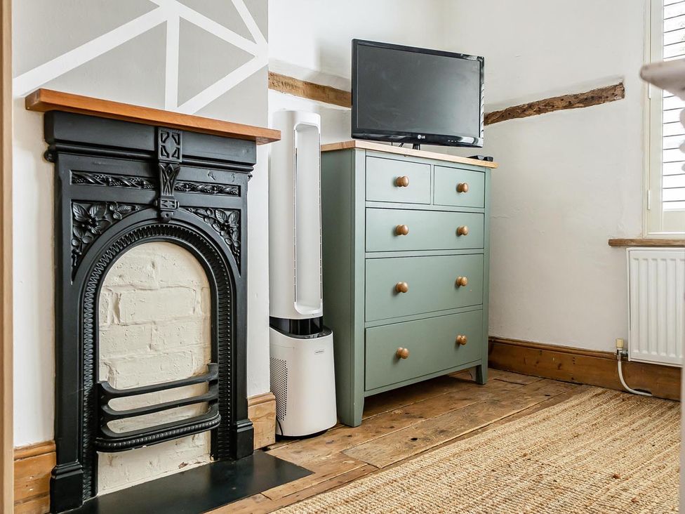 A living room with a fireplace and a television at Quaint Cottage in Charming Evesham