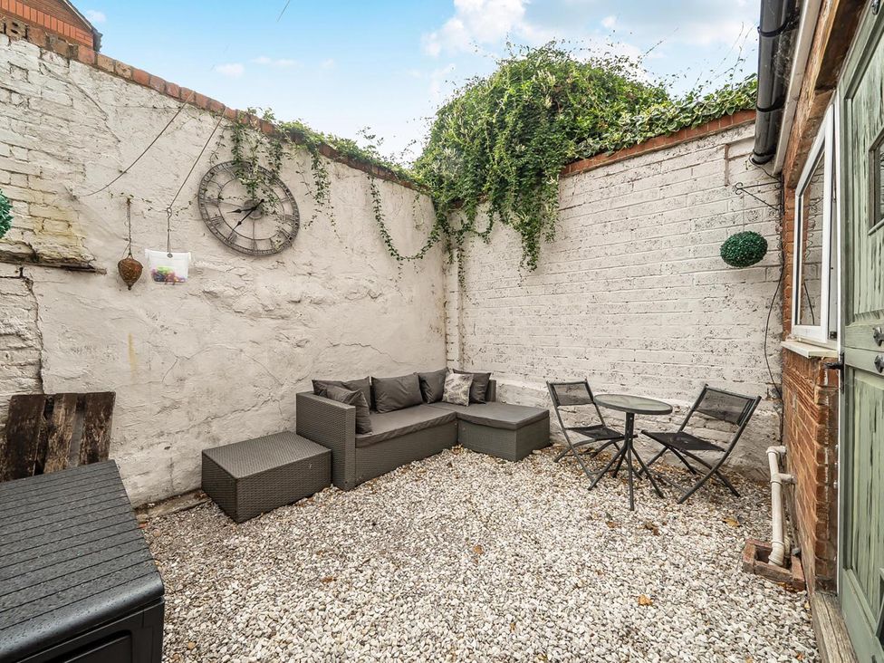 An outdoor seating area with a sofa and table at Quaint Cottage in Charming Evesham