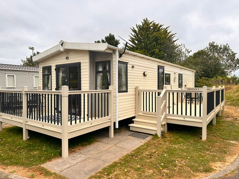 A caravan with a deck and steps at Homely Caravan in Skegness
