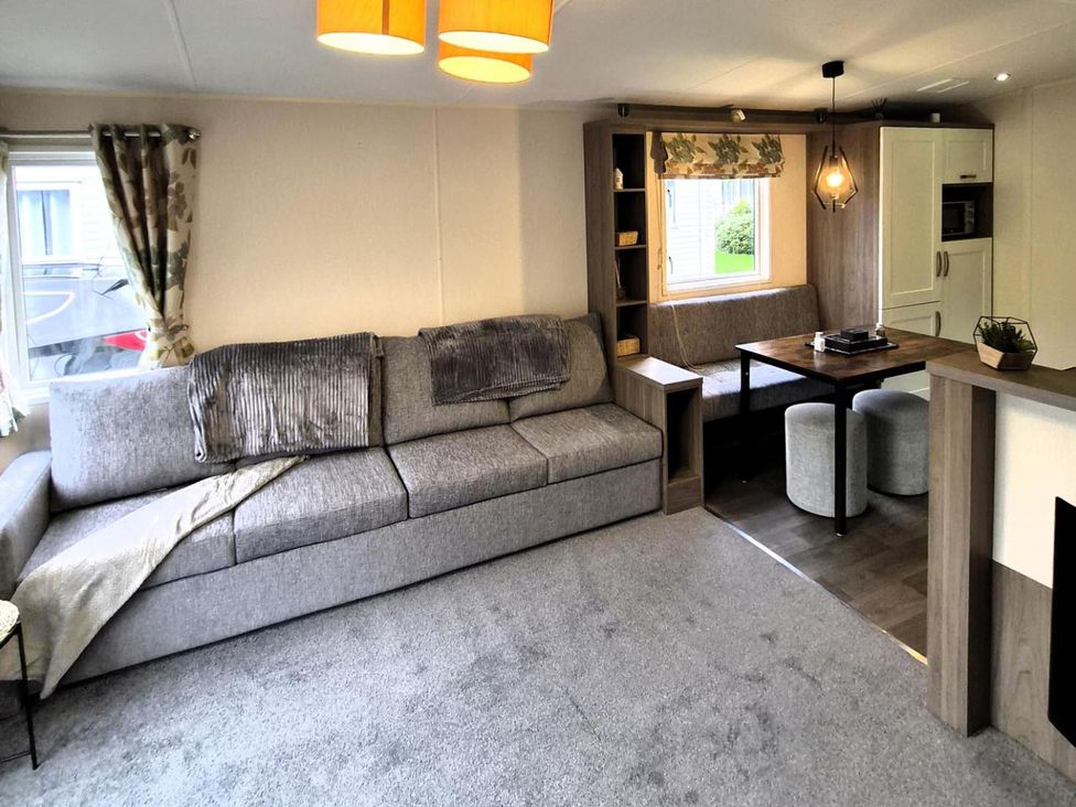 A living room with a sofa and coffee table at Homely Caravan in Skegness