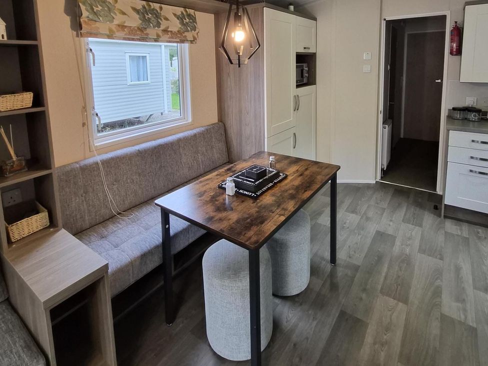 A dining room with a table and seats at Homely Caravan in Skegness