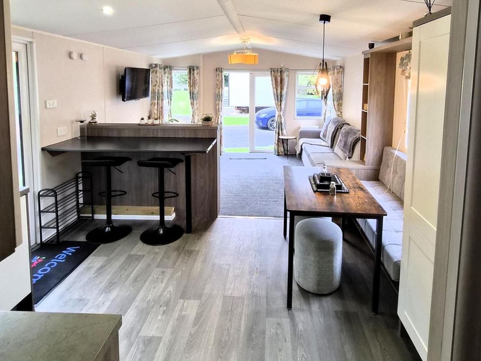 A living room with a breakfast bar and sofa at Homely Caravan in Skegness